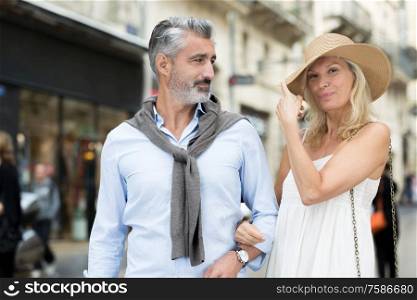 portrait of smiling couple walking and chatting in town