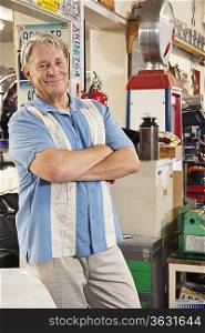 Portrait of smiling elderly man in automobile workshop