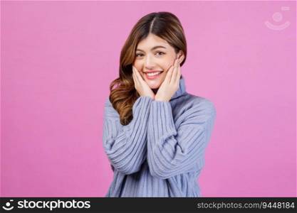 Portrait of Smiling excited young woman with her hands under chin isolated over pink background. People lifestyle and expression concept.