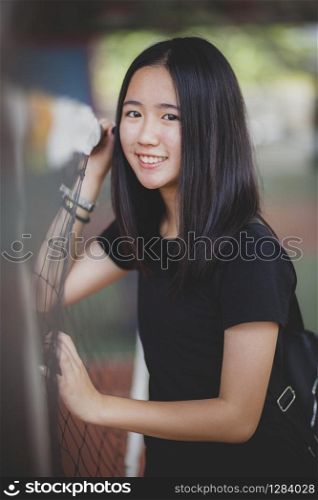portrait of smiling face of asian teenager relaxing in sport stadium