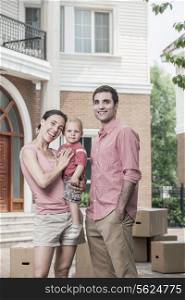 Portrait of smiling family in front of their new home
