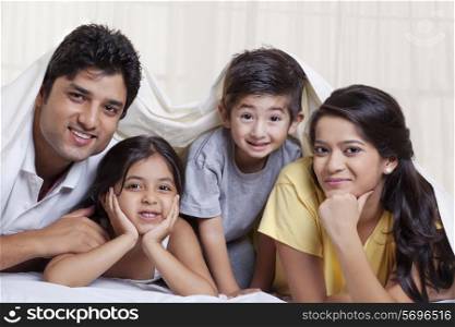 Portrait of smiling family lying in bed