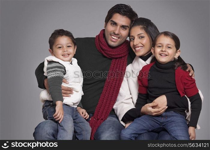 Portrait of smiling family over grey background