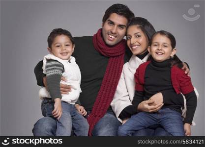Portrait of smiling family over grey background