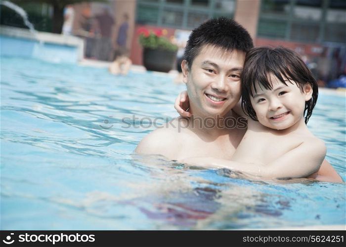 Portrait of smiling father and son in the pool on vacation