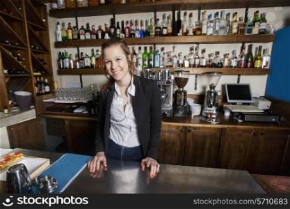 Portrait of smiling female cashier at counter in restaurant