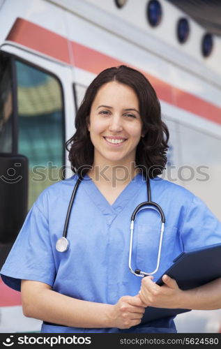 Portrait of smiling female paramedic in front of am ambulance