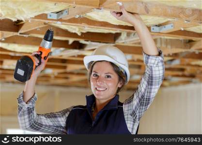 portrait of smiling female worker holding a drill