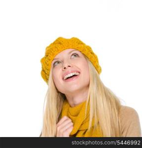 Portrait of smiling girl in autumn clothes looking up on copy space