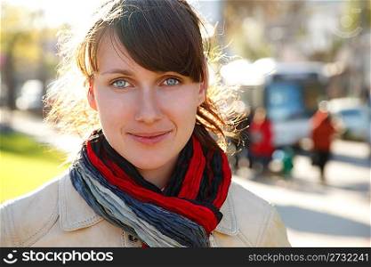 Portrait of smiling girl with bright scarf, in sunny autumn day.