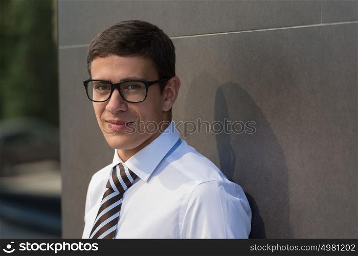 Portrait of smiling handsome businessman on the street looking at camera
