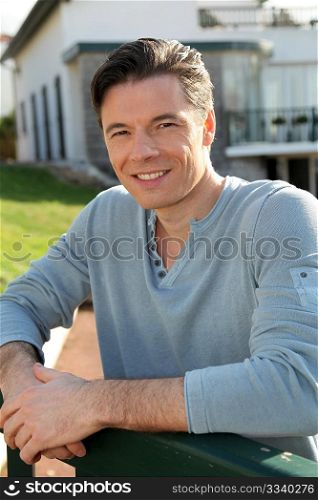 Portrait of smiling handsome man standing in courtyard