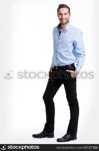 Portrait of smiling happy man in blue shirt and black pants - isolated on white.&#xA;