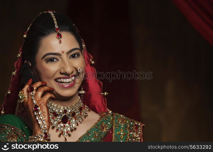 Portrait of smiling Indian bride talking on mobile phone