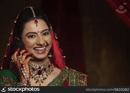 Portrait of smiling Indian bride talking on mobile phone