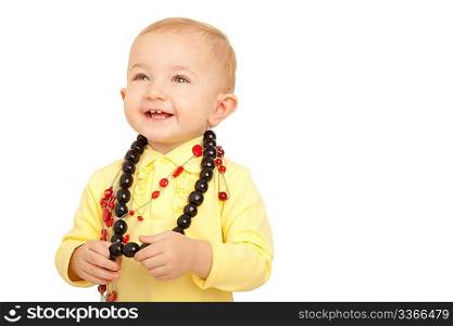 Portrait of smiling little girl in yellow shirt with beads on white background.