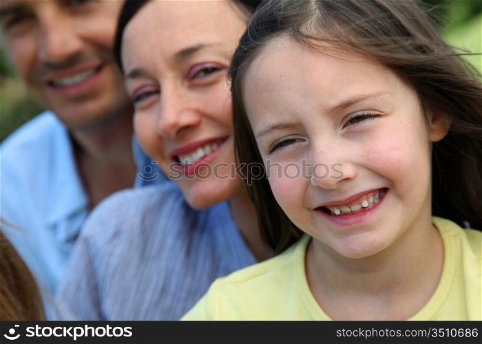 Portrait of smiling little girl with parents in background