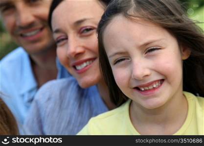 Portrait of smiling little girl with parents in background