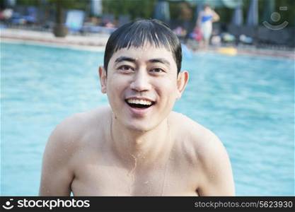 Portrait of smiling man exiting the pool and looking at camera
