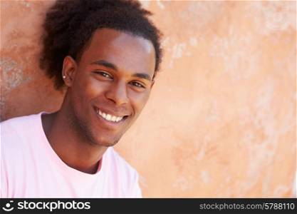 Portrait Of Smiling Man Leaning Against Wall