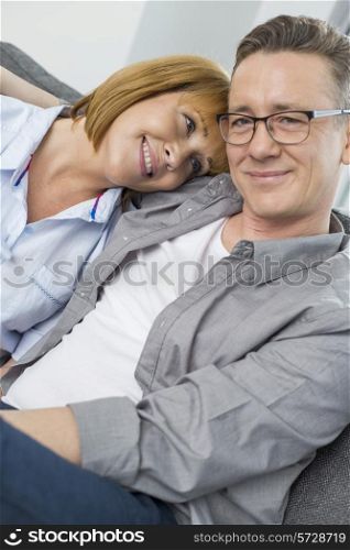 Portrait of smiling man sitting with woman at home