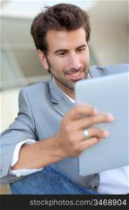 Portrait of smiling man using electronic tablet outside
