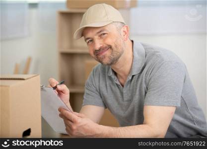 portrait of smiling man writing on clipboard