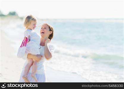 Portrait of smiling mother and baby on beach