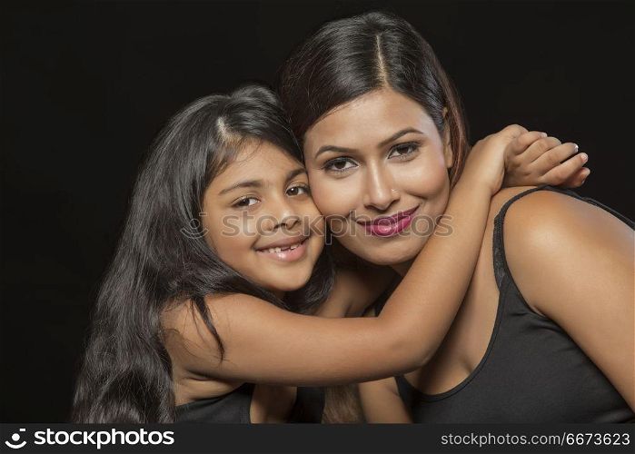 Portrait of smiling mother and daughter embracing