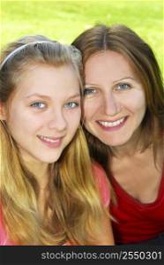 Portrait of smiling mother and daughter in summer park