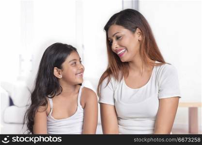 Portrait of smiling mother and daughter looking at each other