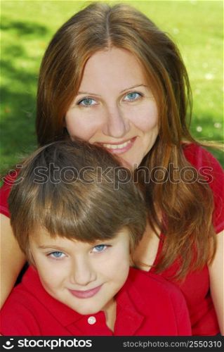 Portrait of smiling mother and son in summer park