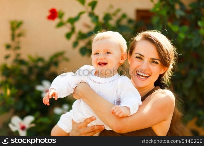 Portrait of smiling mother with baby on street&#xA;