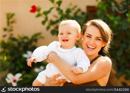 Portrait of smiling mother with baby on street&#xA;