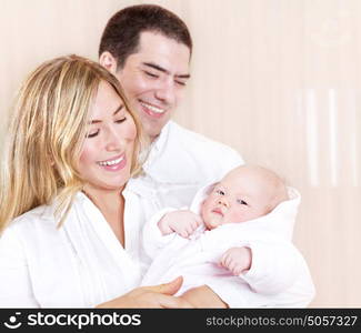 Portrait of smiling parents looking on their sweet newborn baby, enjoying parenthood at home, happy and healthy childhood