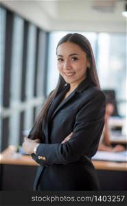 Portrait of smiling pretty young business woman sitting on modern co-working workplace, Start-up office background