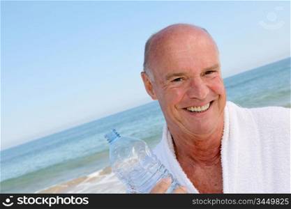 Portrait of smiling senior man with bottle of water