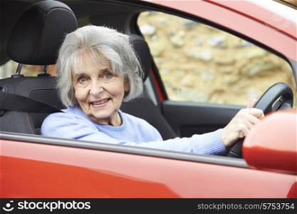 Portrait Of Smiling Senior Woman Driving Car