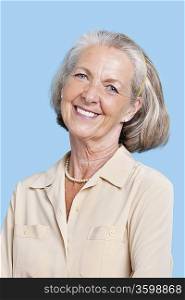 Portrait of smiling senior woman in casuals against blue background
