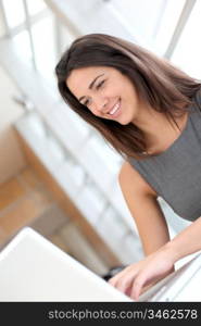 Portrait of smiling student girl working on laptop