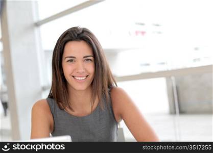 Portrait of smiling student girl working on laptop