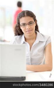 Portrait of smiling student in front of laptop computer