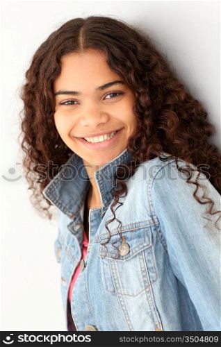 Portrait of smiling teenager leaning on wall