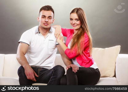 Portrait of smiling woman and man. Happy couple.. Portrait of smiling woman and man sitting on sofa posing. Happy joyful couple.