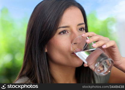 Portrait of smiling woman holding glass of water