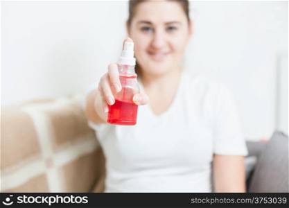Portrait of smiling woman holding medical spray