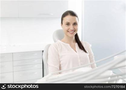Portrait of smiling woman patient sitting on chair at clinic