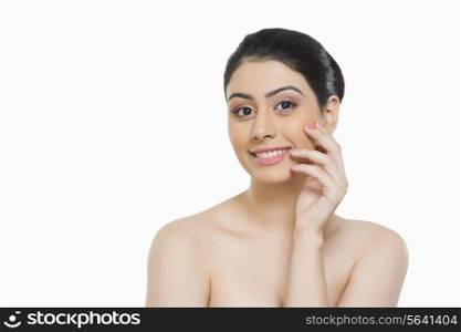 Portrait of smiling woman touching cheek over white background