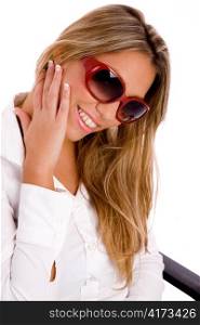 portrait of smiling woman wearing sunglasses with white background