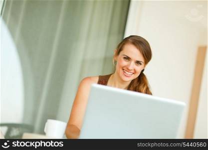 Portrait of smiling woman working on laptop